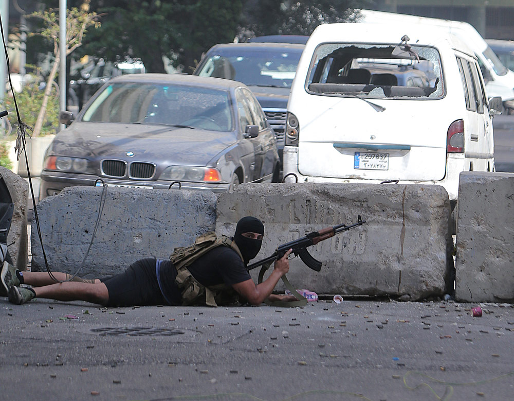 14 October 2021, Lebanon, Beirut: A gunman takes a position during clashes in the area of Tayouneh, after gunfire erupted at a protest by supporters of the Shiite Hezbollah movement against the judge investigating the city's port blast, near the former civil war front-line between Muslim Shiite and Christian areas. At least six people were killed and 32 injured in Beirut. Photo: Haitham Moussawi/APA Images via ZUMA Press Wire/dpa.